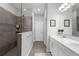 Modern bathroom featuring double sinks, quartz countertop, and a tiled walk-in shower at 12565 Ryegrass Loop, Parrish, FL 34219