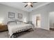 Bright bedroom featuring a ceiling fan, tray ceiling, plush carpet, and comfortable seating at 12565 Ryegrass Loop, Parrish, FL 34219