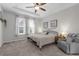 Bright bedroom featuring a ceiling fan, tray ceiling, plush carpet, and comfortable seating at 12565 Ryegrass Loop, Parrish, FL 34219