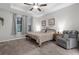 Bright bedroom featuring a ceiling fan, tray ceiling, plush carpet, and comfortable seating at 12565 Ryegrass Loop, Parrish, FL 34219