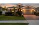 Well-lit house at dusk with manicured lawn and inviting curb appeal at 12565 Ryegrass Loop, Parrish, FL 34219