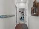 Hallway featuring neutral walls, decorative hooks, and an inviting doorway to a carpeted room at 12565 Ryegrass Loop, Parrish, FL 34219