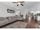 Bright living room boasts a large sectional sofa, ceiling fan, and lovely views of the adjacent kitchen at 12565 Ryegrass Loop, Parrish, FL 34219