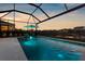 Beautifully lit screened-in pool at twilight, offering a tranquil outdoor oasis at 12565 Ryegrass Loop, Parrish, FL 34219