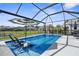 Relaxing screened-in pool area featuring built-in lounge chairs, umbrella and playhouse at 12565 Ryegrass Loop, Parrish, FL 34219