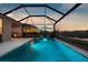 Tranquil screened-in pool featuring a calming lake view at twilight, ideal for relaxation at 12565 Ryegrass Loop, Parrish, FL 34219