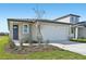 Charming single-story home featuring a large white garage door and neutral colored exterior paint at 14061 Crutchfield Ct, Parrish, FL 34219