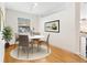 Cozy dining area features a round table with four chairs, wood floors, and natural light from the window at 14230 Cattle Egret Pl, Lakewood Ranch, FL 34202