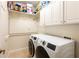 Laundry room featuring a front load washer and dryer with storage above at 14230 Cattle Egret Pl, Lakewood Ranch, FL 34202