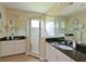 Bright bathroom featuring double sinks, granite countertops, and a glass-enclosed shower, with tile floors at 16711 Rivers Reach Blvd, Parrish, FL 34219
