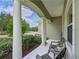 Welcoming front porch with classic columns, outdoor seating, and views of the landscaped front yard at 16711 Rivers Reach Blvd, Parrish, FL 34219