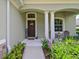Inviting front porch with decorative columns, a welcome sign, and outdoor seating surrounded by lush greenery at 16711 Rivers Reach Blvd, Parrish, FL 34219
