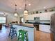 Open kitchen with granite countertops, white cabinets, stainless steel appliances, and colorful bar stools at 16711 Rivers Reach Blvd, Parrish, FL 34219