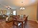 Open-concept living and dining area featuring hardwood floors, a cozy sofa, and a dining table set for eight at 16711 Rivers Reach Blvd, Parrish, FL 34219