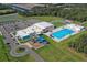 Aerial view of community amenities featuring a pool, playground, and recreational building at 16849 Castoro Dr, Port Charlotte, FL 33953