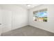 Cozy bedroom with a bright window, ceiling fan, and soft gray carpet at 16849 Castoro Dr, Port Charlotte, FL 33953