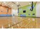 Spacious gymnasium featuring basketball hoops, polished hardwood floors, and bright lighting at 16849 Castoro Dr, Port Charlotte, FL 33953