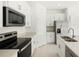 Bright kitchen featuring white cabinets, stainless steel appliances, and stone countertops at 16849 Castoro Dr, Port Charlotte, FL 33953