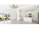Bright, open-concept living area with sliding glass doors and a modern kitchen featuring white cabinetry at 16849 Castoro Dr, Port Charlotte, FL 33953