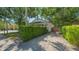 Quaint single-story home with a well-maintained green hedge and gravel driveway at 1742 9Th St, Sarasota, FL 34236