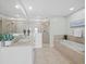Spacious bathroom featuring double sinks, a glass-enclosed shower, and a luxurious soaking tub at 1771 Ringling Blvd # 1104, Sarasota, FL 34236