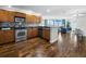 Modern kitchen with stainless steel appliances and wood cabinets opening to living space at 1771 Ringling Blvd # 1104, Sarasota, FL 34236