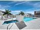 Outdoor pool and hot tub with lounge chairs and umbrellas with city views in the background at 1771 Ringling Blvd # 1104, Sarasota, FL 34236
