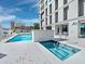 Beautiful outdoor pool and hot tub area surrounded by white brick and lounge seating at 1771 Ringling Blvd # 1104, Sarasota, FL 34236