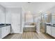 Bathroom showcasing a soaking tub, glass enclosed shower, double vanity and white cabinets at 18045 Polo Trail St, Bradenton, FL 34211