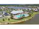 Aerial view of clubhouse with pool, playground, and lake in a beautiful community with manicured landscaping at 18045 Polo Trail St, Bradenton, FL 34211