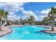 Relaxing community pool and deck with palm trees, lounge seating, and a play area at 18045 Polo Trail St, Bradenton, FL 34211
