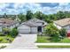 Striking curb appeal with a home featuring a tile roof, landscaped yard, and three car garage at 18045 Polo Trail St, Bradenton, FL 34211