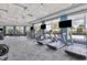 Well-equipped fitness center with modern treadmills, ellipticals, and weight machines facing views of the pool at 18045 Polo Trail St, Bradenton, FL 34211