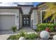 Elegant double front doors, stone accents, and lush landscaping create a welcoming entrance at 18045 Polo Trail St, Bradenton, FL 34211