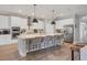Modern kitchen with white cabinets, stainless steel appliances, and large island with seating at 18045 Polo Trail St, Bradenton, FL 34211