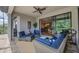 Relaxing lanai featuring wicker furniture with blue cushions, a ceiling fan, and view to the pool at 18045 Polo Trail St, Bradenton, FL 34211