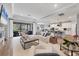 Open-concept living room with fireplace, kitchen, island seating, and sliding glass doors to outdoor space at 18045 Polo Trail St, Bradenton, FL 34211