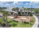Community playground with multiple play structures and benches surrounded by lush landscaping and palm trees at 18045 Polo Trail St, Bradenton, FL 34211