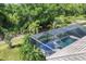 Aerial perspective of a screened pool with a view of the surrounding lush greenery and landscaping at 18045 Polo Trail St, Bradenton, FL 34211