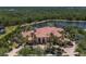 Expansive waterfront home surrounded by lush landscaping and mature trees with a tranquil lake in the background at 19208 Ganton Ave, Lakewood Ranch, FL 34202