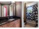 Modern bathroom with a granite vanity and a black-and-white tiled shower and bathtub at 19208 Ganton Ave, Lakewood Ranch, FL 34202