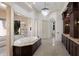 Bright bathroom featuring a soaking tub, a separate glass shower, and custom dark wood cabinets at 19208 Ganton Ave, Lakewood Ranch, FL 34202