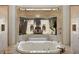 A luxurious soaking tub with jets, surrounded by travertine, and a private garden view at 19208 Ganton Ave, Lakewood Ranch, FL 34202