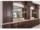 Double vanity bathroom with custom wood cabinetry, granite counters, and decorative lighting at 19208 Ganton Ave, Lakewood Ranch, FL 34202