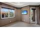 Bedroom with neutral paint, a TV, a window, and a door to an outdoor balcony at 19208 Ganton Ave, Lakewood Ranch, FL 34202