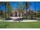 Elegant home featuring lush landscaping, mature trees, and a circular brick driveway at 19208 Ganton Ave, Lakewood Ranch, FL 34202
