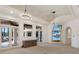 Spacious living room featuring elegant chandeliers, a decorative ceiling, and multiple TV screens at 19208 Ganton Ave, Lakewood Ranch, FL 34202