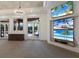 Bright living room with a wall of TVs, opening to a patio and pool area, perfect for entertaining and relaxation at 19208 Ganton Ave, Lakewood Ranch, FL 34202