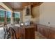 Outdoor kitchen with bar seating, stainless steel appliances, tile backsplash, and decorative hanging lanterns at 19208 Ganton Ave, Lakewood Ranch, FL 34202