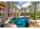 A luxurious outdoor pool area with palm trees, integrated spa, and serene water features at 19208 Ganton Ave, Lakewood Ranch, FL 34202